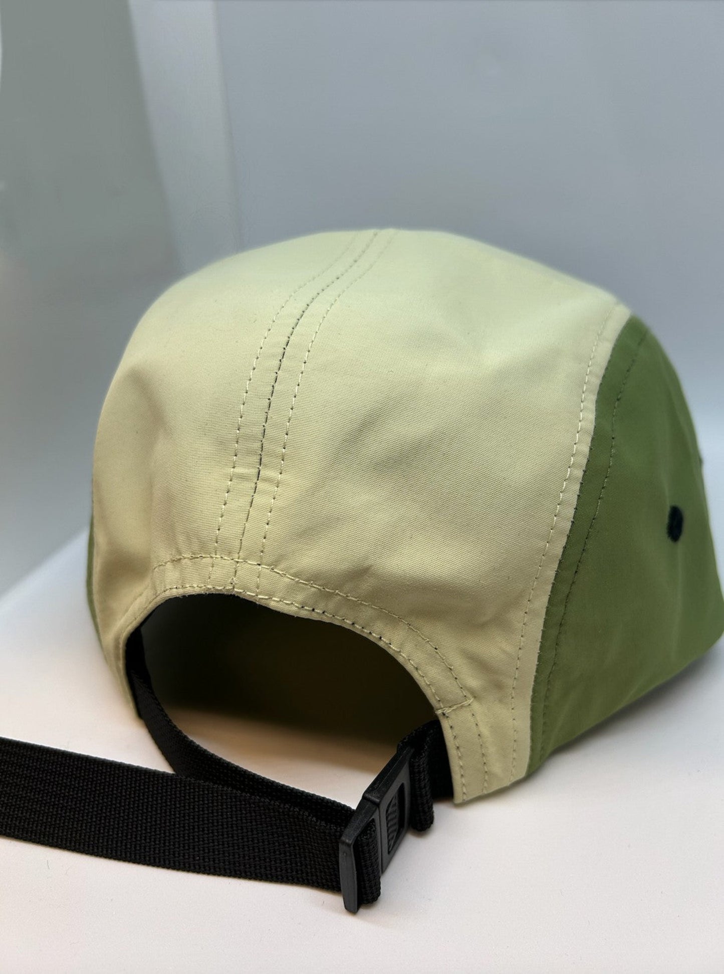 back of nylon hat in yellow and green with plastic buckle closure